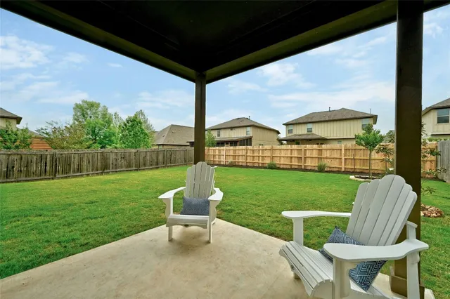 a view of a two chairs and table in backyard