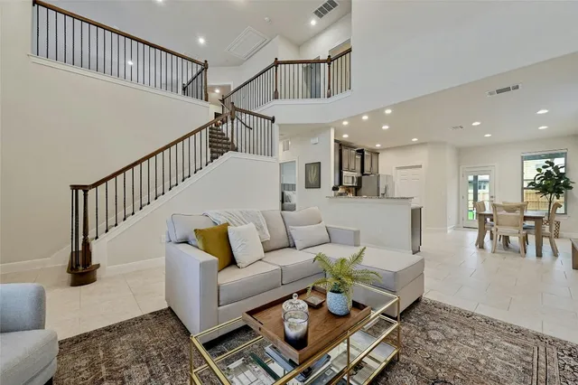 a living room with furniture and a dining table with wooden floor