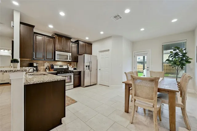 a kitchen with kitchen island granite countertop wooden cabinets and stainless steel appliances