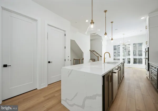 a kitchen with a sink a stove and a wooden floor