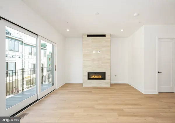 a view of an empty room with a fireplace and a window