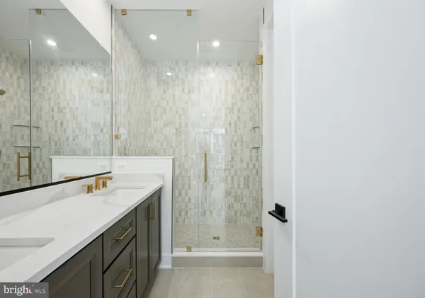 a bathroom with a shower sink and mirror