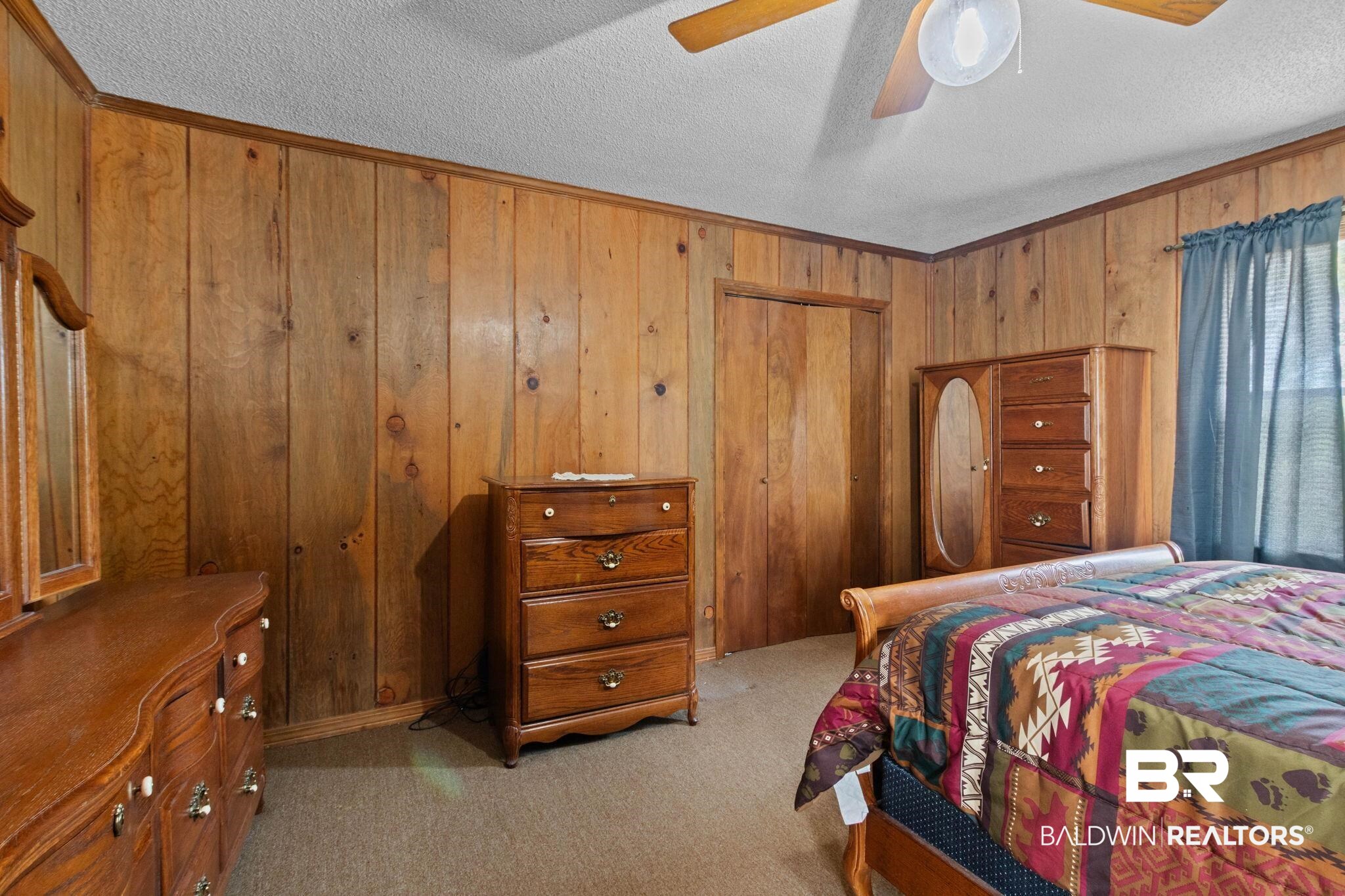 8153 Bryant's Lndg Road Stockton, AL 36579 - Photo 38 of 87 Room featuring wood paneling on all walls, a neutral carpet, and a white textured ceiling
