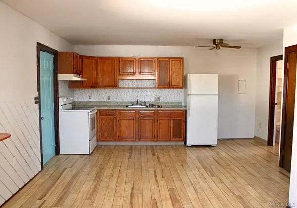 a kitchen with kitchen island wooden floors appliances and cabinets
