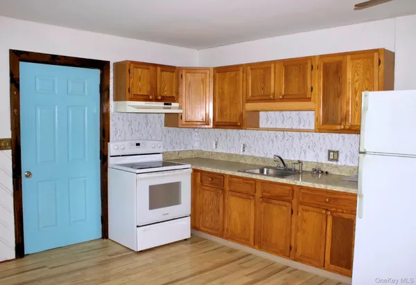 a kitchen with stainless steel appliances granite countertop a sink and cabinets with wooden floors