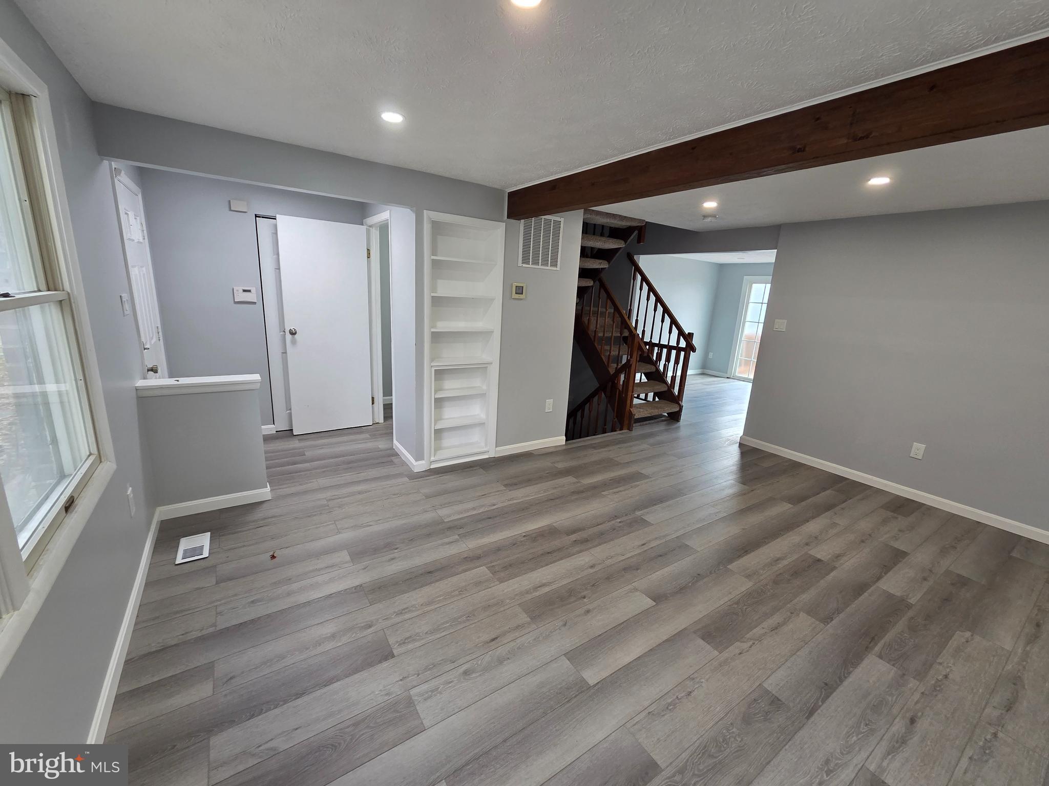 17923 Ashton Club Way Ashton, MD 20861 - Photo 2 of 21 a view of an empty room with wooden floor and stairs