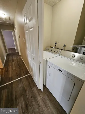a view of a hallway with wooden floor and furniture