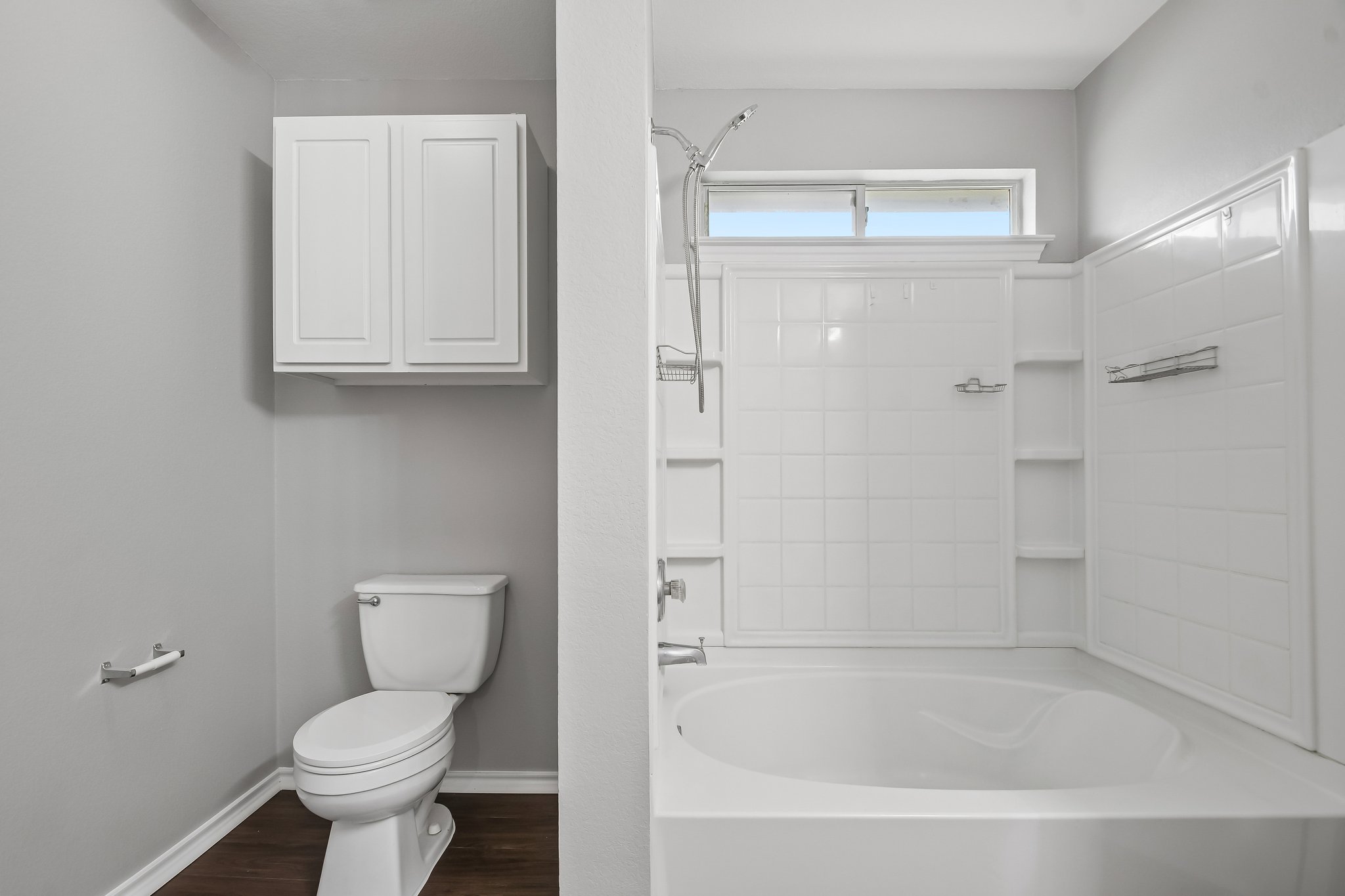 610 Lavaca Loop Elgin, TX 78621 - Photo 22 of 37 A well-appointed bathroom offers a clean tub, shower, and toilet with hardwood-style flooring.