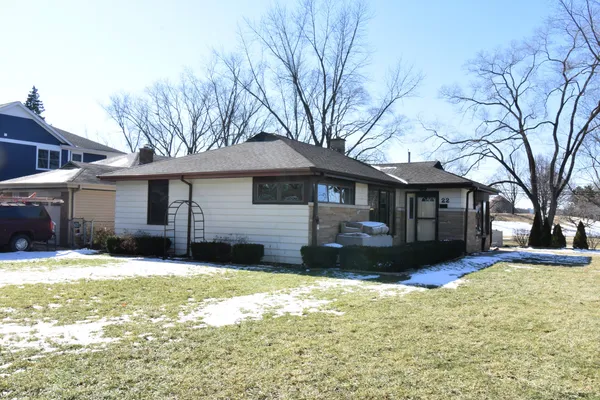 a front view of a house with a yard covered in snow