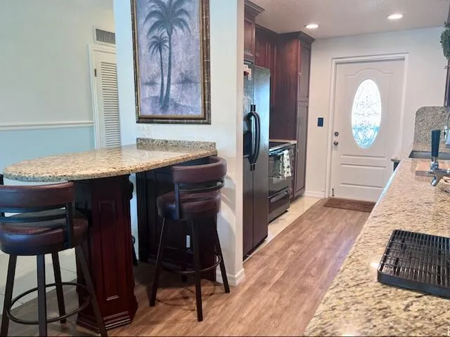 a view of hallway with wooden floor and cabinet