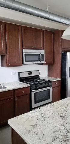a kitchen with a stove a sink and a refrigerator