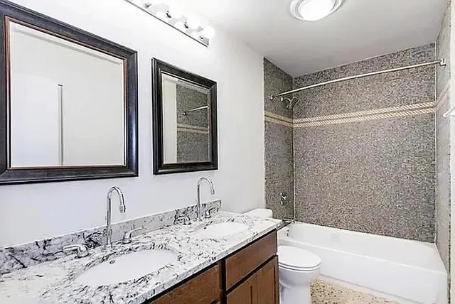 a bathroom with a granite countertop sink toilet and shower
