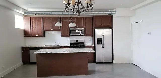 a kitchen with stainless steel appliances granite countertop a sink refrigerator and microwave