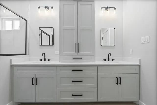 a bathroom with a double vanity sink mirror and shower