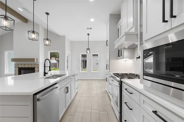 a kitchen with stainless steel appliances a stove sink and cabinets