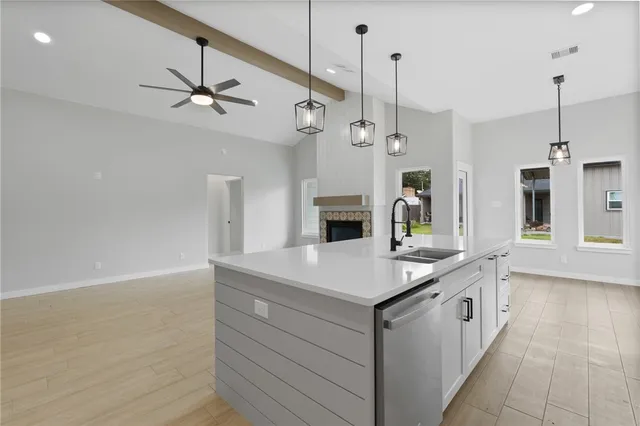 a kitchen with a sink a chandelier stainless steel appliances and a chandelier