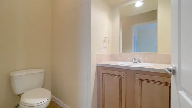 a bathroom with a toilet a sink and mirror