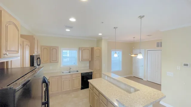 a large kitchen with kitchen island a sink stainless steel appliances and cabinets