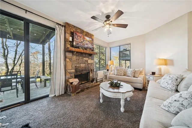 a living room with furniture a fireplace and a large window