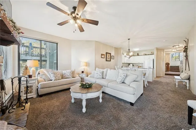 a living room with furniture a table and a chandelier
