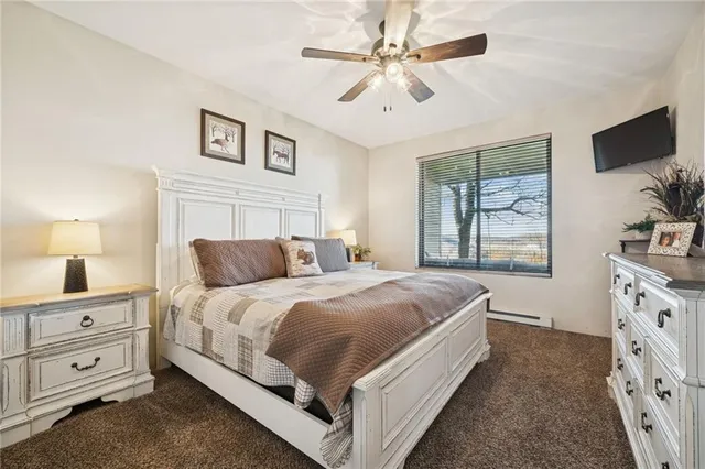 a bedroom with a large bed and a tv on the dresser