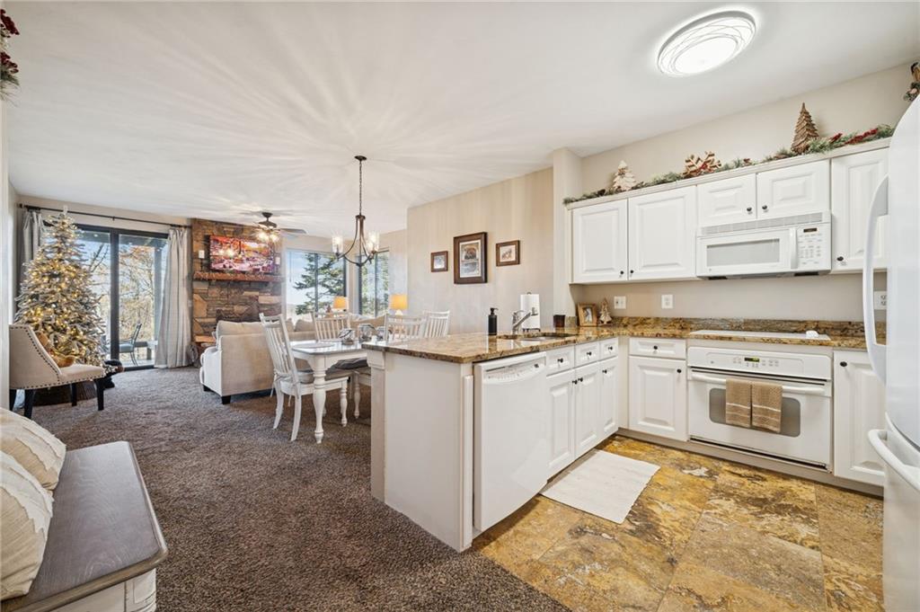 5023 Summit View Court Hidden Valley, PA 15502 - Photo 6 of 41 a open kitchen with stainless steel appliances granite countertop a stove top oven a sink dishwasher and white cabinets next to a window