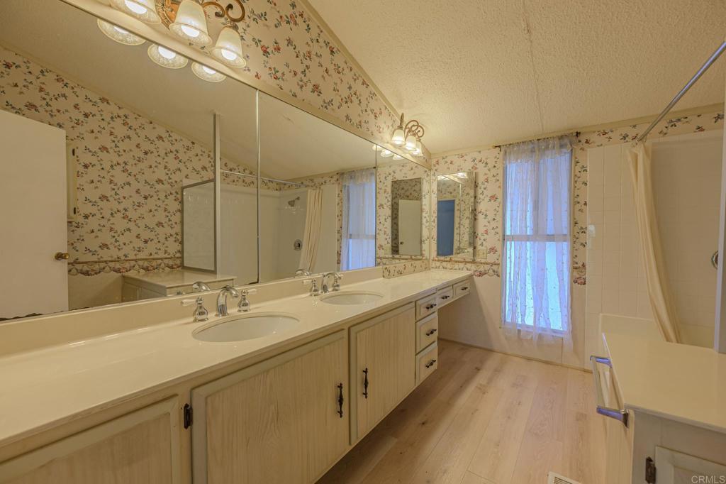 4650 Dulin Road, Unit 153 Fallbrook, CA 92003 - Photo 16 of 24 a spacious bathroom with a double vanity sink a mirror and a shower