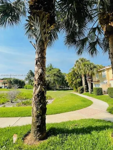 a front view of a house with a yard and potted plants