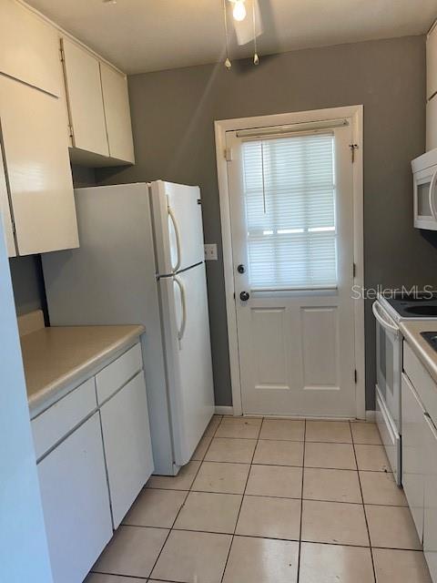 2501 Sheridan Road Mount Dora, FL 32757 - Photo 10 of 33 a kitchen with a refrigerator a stove top oven and cabinets