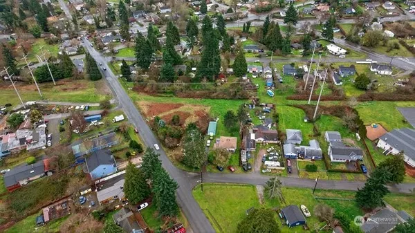 an aerial view of a residential houses with outdoor space and trees