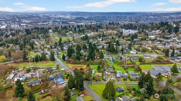 an aerial view of residential houses with outdoor space and trees