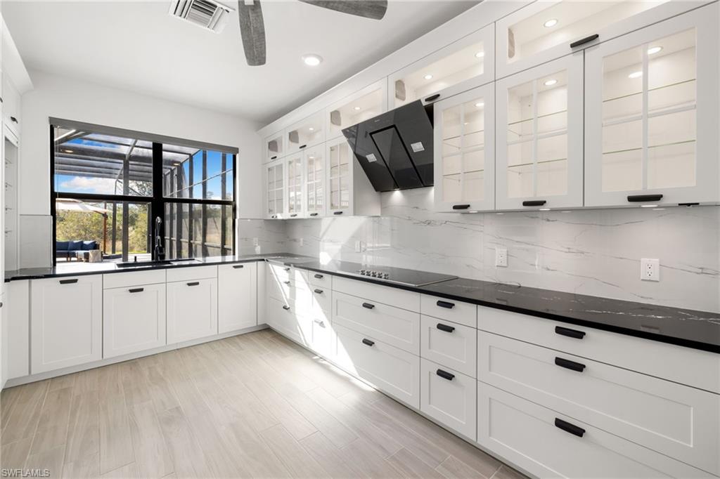 19824 Beverly Park Road Estero, FL 33928 - Photo 16 of 50 a kitchen with stainless steel appliances white cabinets and a wooden floor