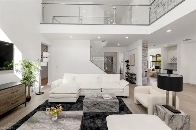 a kitchen with granite countertop a stove a sink and white cabinets with wooden floor