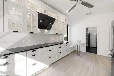 a kitchen with granite countertop a sink and a stove top oven