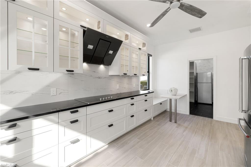 19824 Beverly Park Road Estero, FL 33928 - Photo 20 of 50 a kitchen with granite countertop a sink and a stove top oven