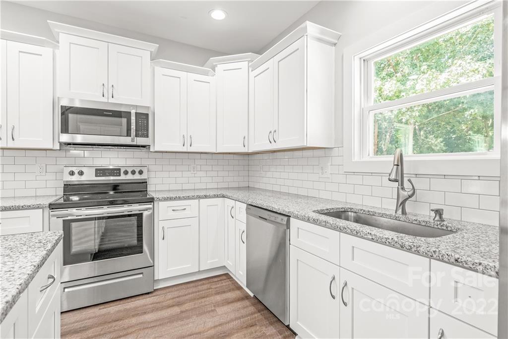 8621 Reedy Creek Road Charlotte, NC 28215 - Photo 13 of 22 a kitchen with granite countertop white cabinets white stainless steel appliances and a sink