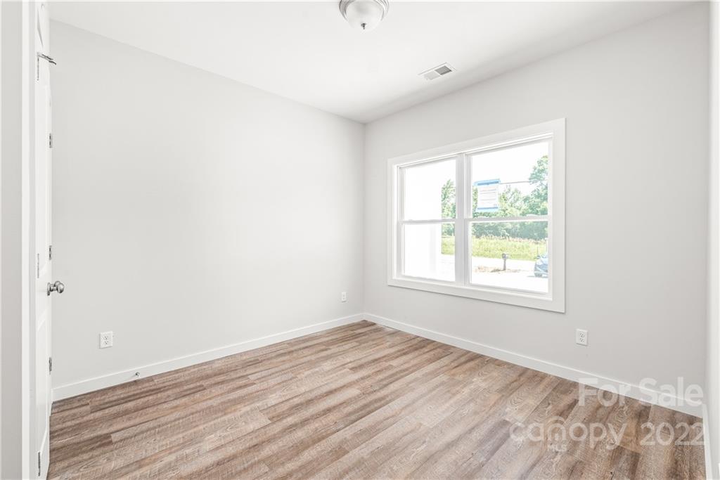 8621 Reedy Creek Road Charlotte, NC 28215 - Photo 18 of 22 an empty room with wooden floor and windows