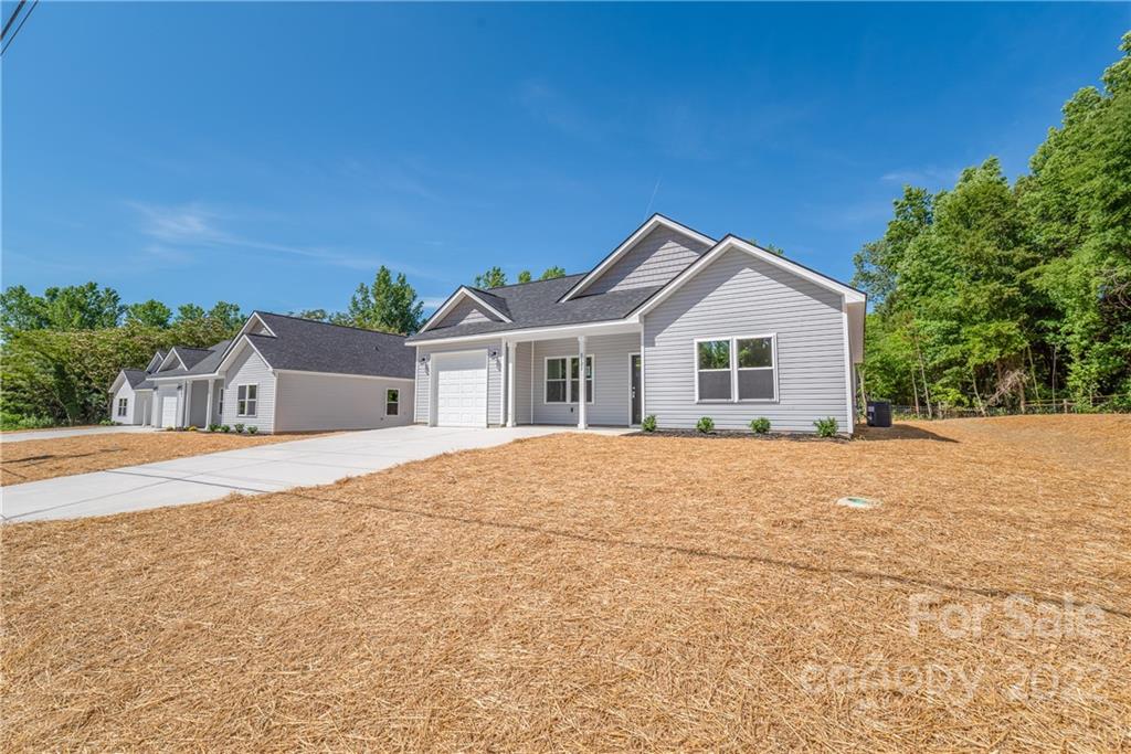8621 Reedy Creek Road Charlotte, NC 28215 - Photo 4 of 22 a front view of a house with a yard