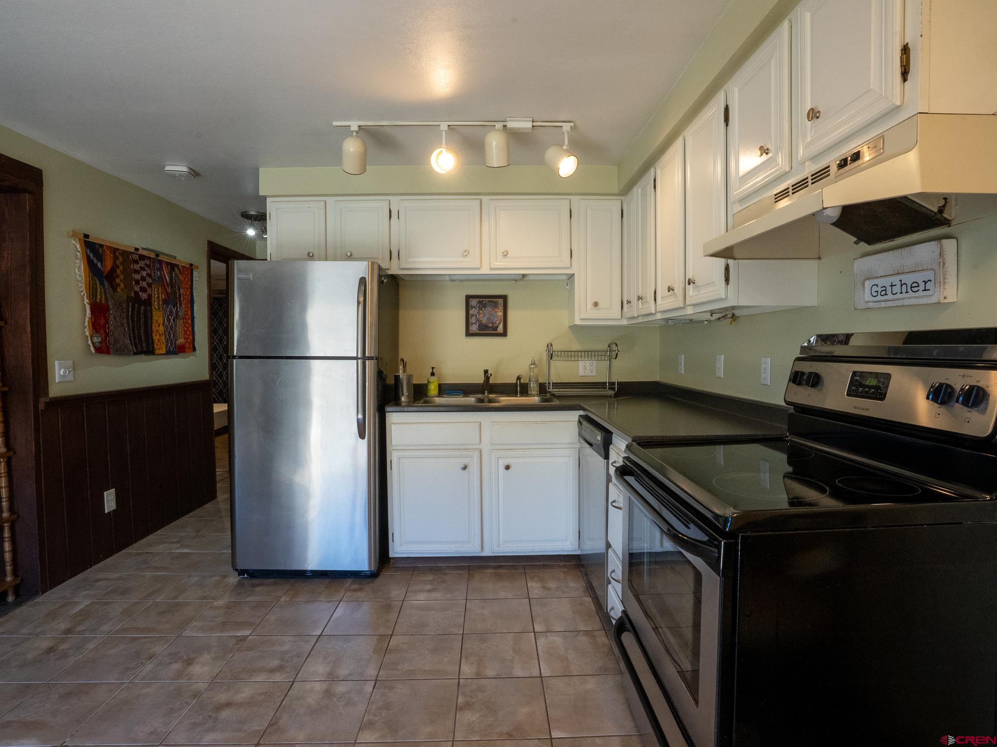 701 Gothic Road, Unit 338 Crested Butte, CO 81225 - Photo 12 of 42 a kitchen with a refrigerator a stove a microwave and cabinets