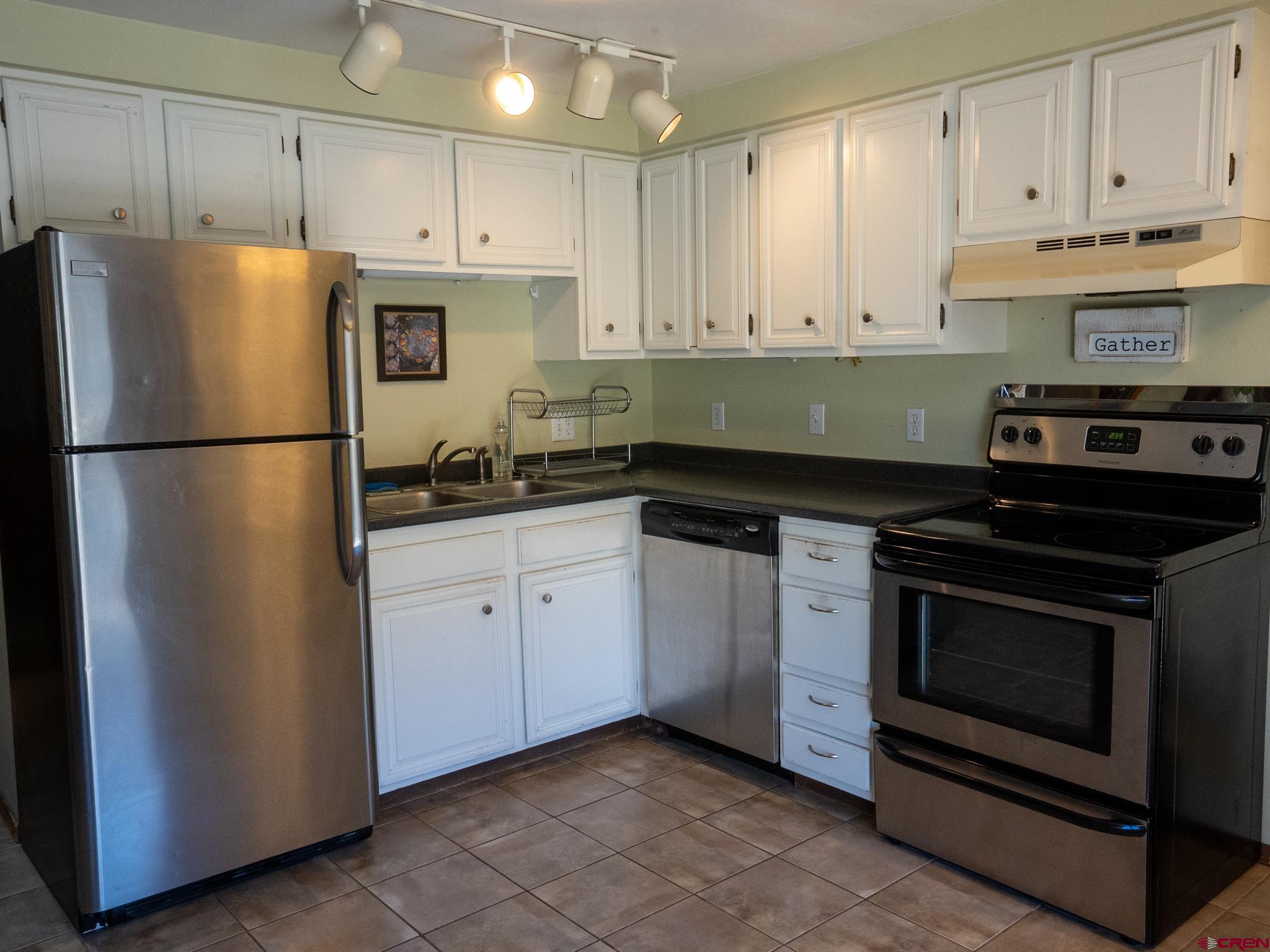 701 Gothic Road, Unit 338 Crested Butte, CO 81225 - Photo 13 of 42 a kitchen with a refrigerator stove and white cabinets