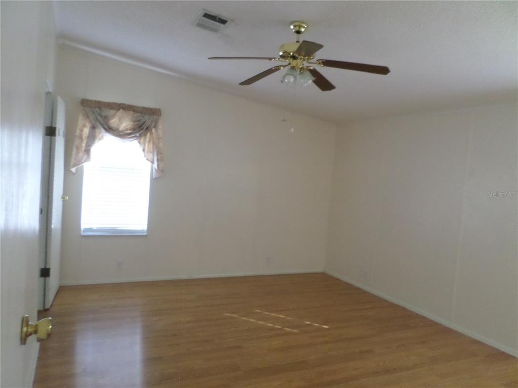 1690 Southwest 35th Circle Okeechobee, FL 34974 - Photo 15 of 23 an empty room with a window and a ceiling fan