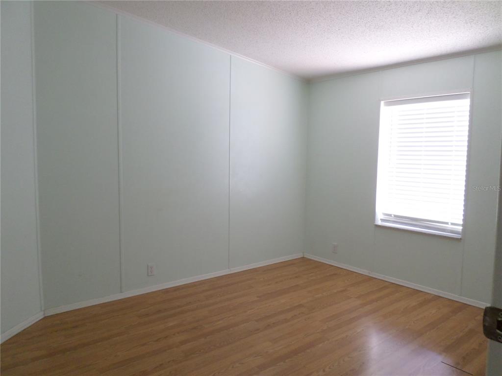 1690 Southwest 35th Circle Okeechobee, FL 34974 - Photo 19 of 23 an empty room with wooden floor and windows