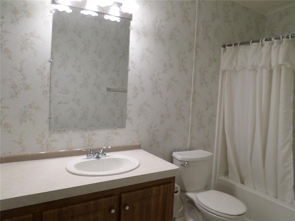 1690 Southwest 35th Circle Okeechobee, FL 34974 - Photo 21 of 23 a bathroom with a sink toilet and a mirror