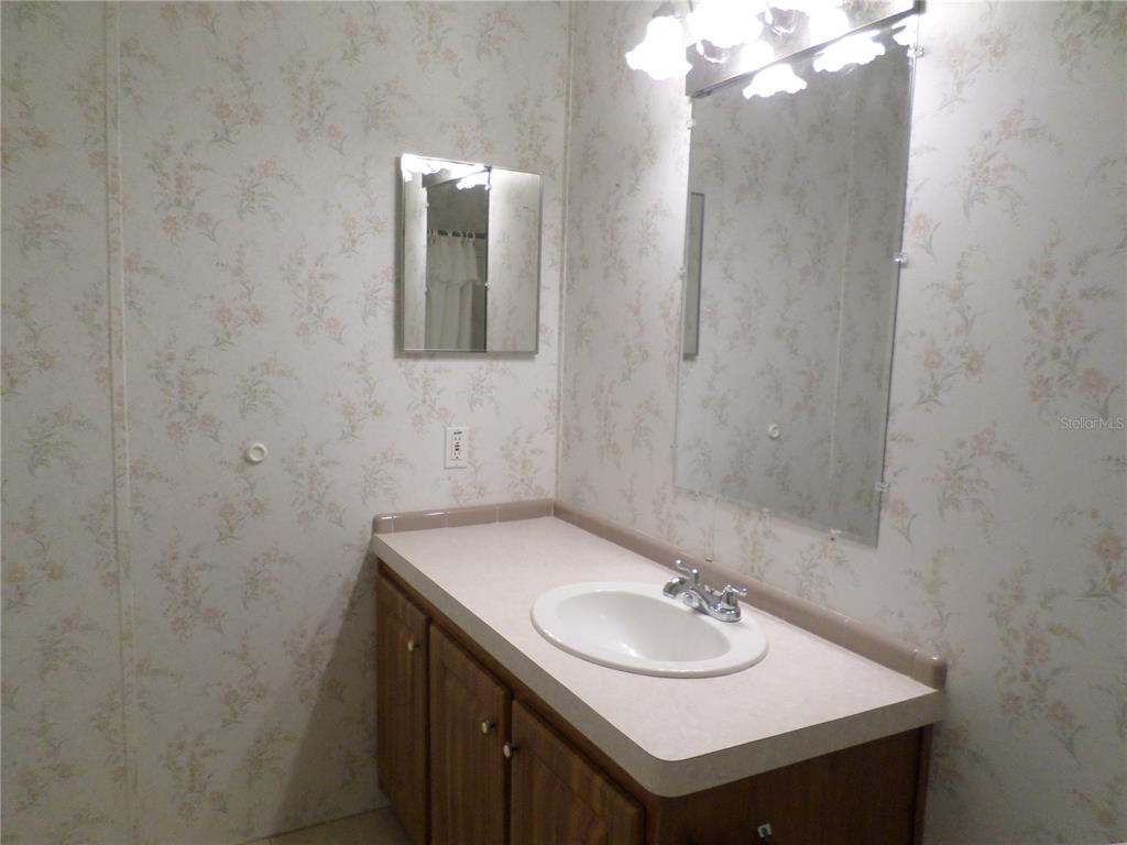 1690 Southwest 35th Circle Okeechobee, FL 34974 - Photo 22 of 23 a bathroom with a sink and a mirror