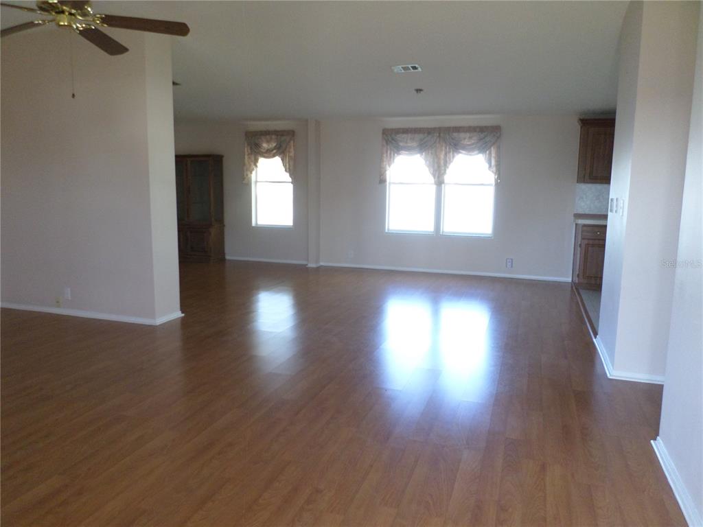 1690 Southwest 35th Circle Okeechobee, FL 34974 - Photo 10 of 23 an empty room with wooden floor and windows