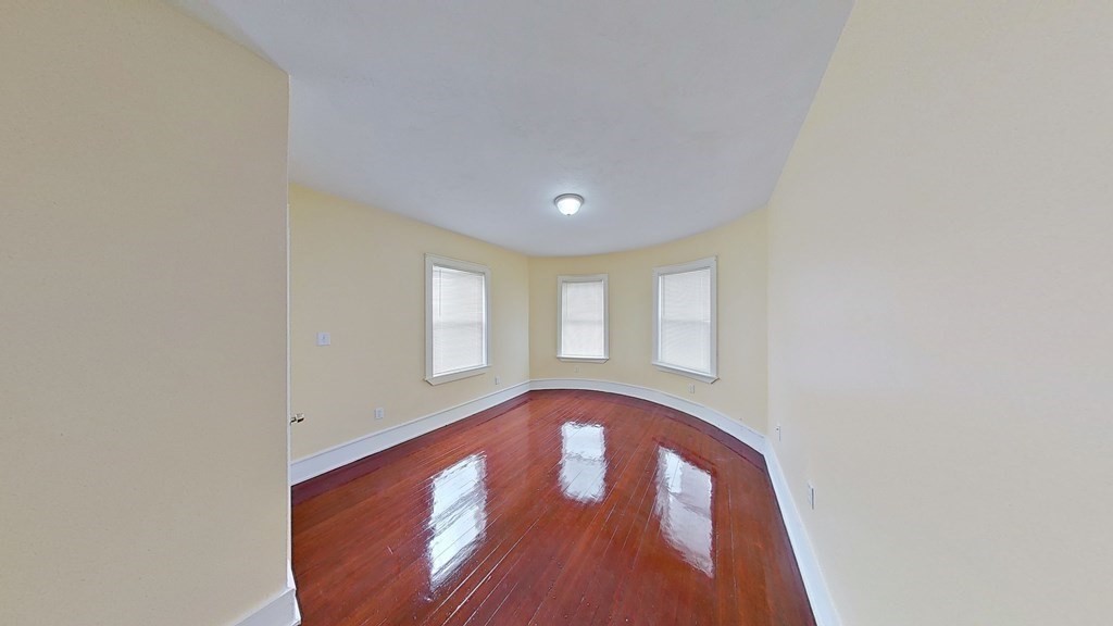 3 Dunlap Street Boston, MA 02124 - Photo 29 of 42 a view of an empty room with wooden floor and a window