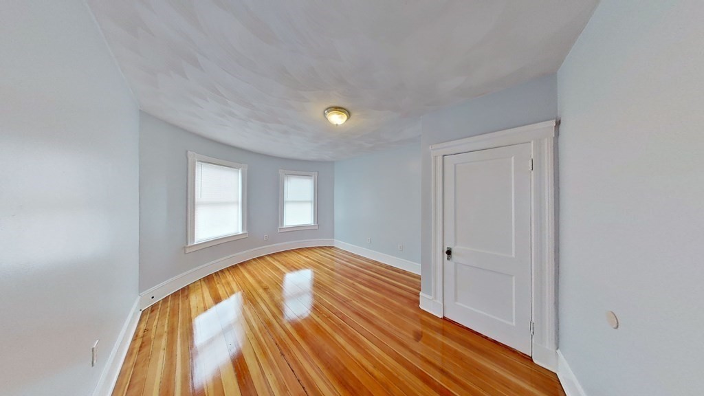 3 Dunlap Street Boston, MA 02124 - Photo 35 of 42 a view of an empty room with wooden floor and a window