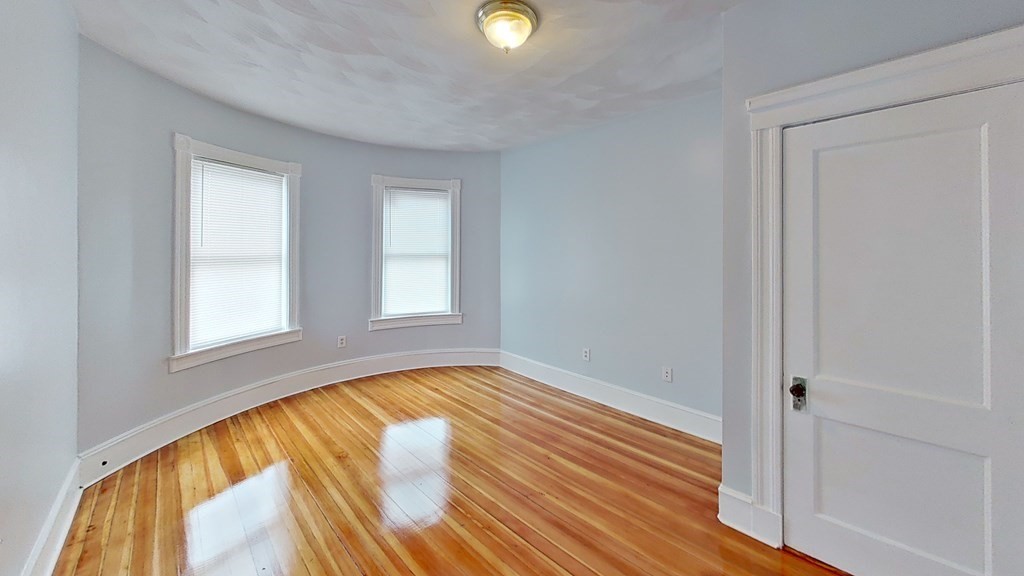 3 Dunlap Street Boston, MA 02124 - Photo 37 of 42 a view of an empty room with wooden floor and a window