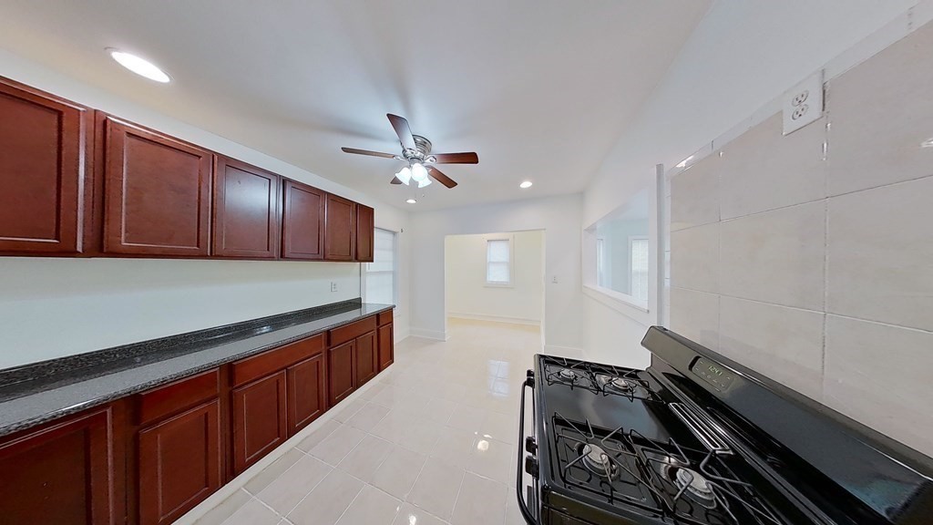 3 Dunlap Street Boston, MA 02124 - Photo 6 of 42 a kitchen with wooden cabinets and stove