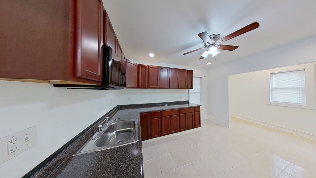 3 Dunlap Street Boston, MA 02124 - Photo 7 of 42 a kitchen with stainless steel appliances granite countertop a sink a stove and a refrigerator with wooden floor